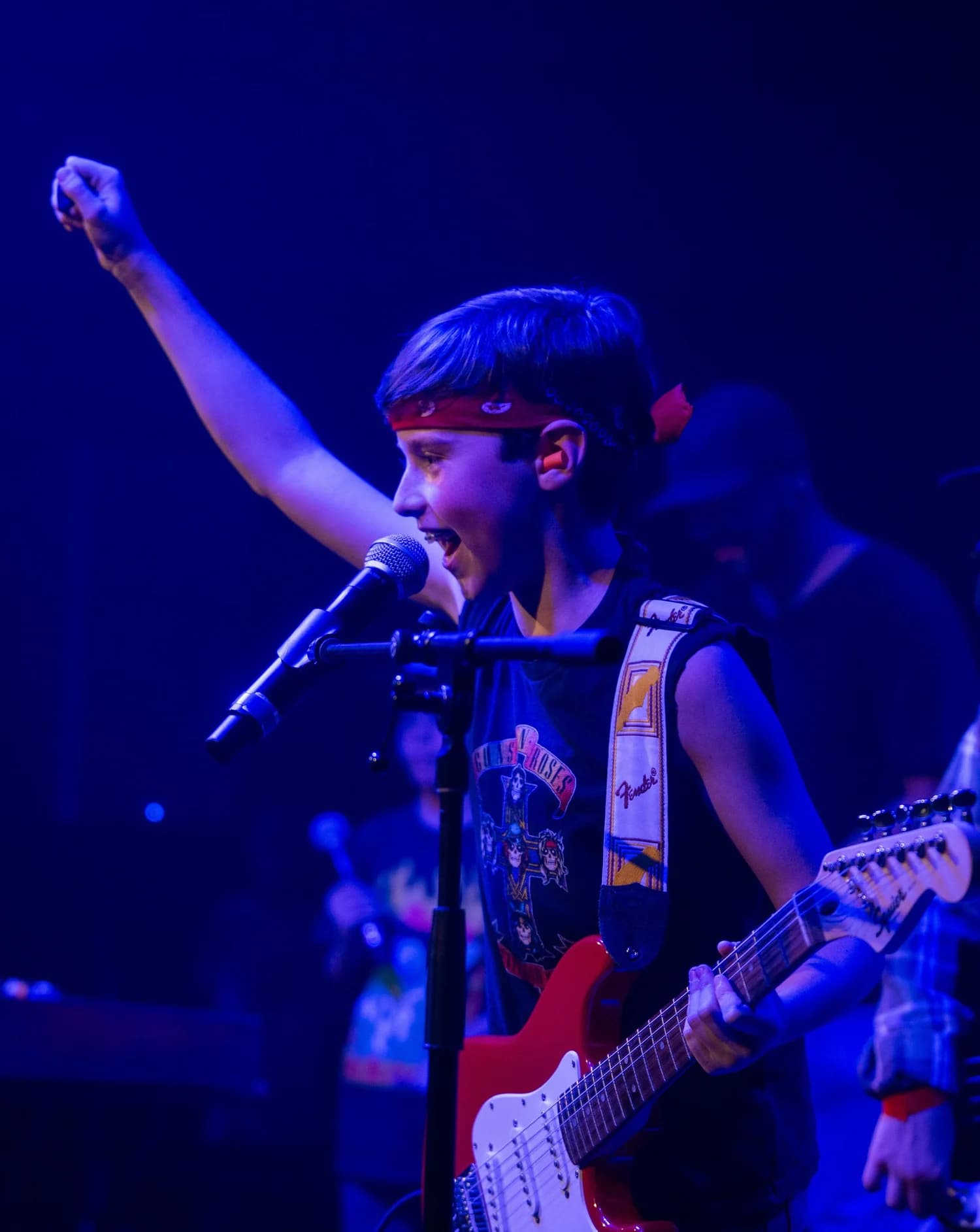 Young performer singing on stage at a Wynwood School of Music recital