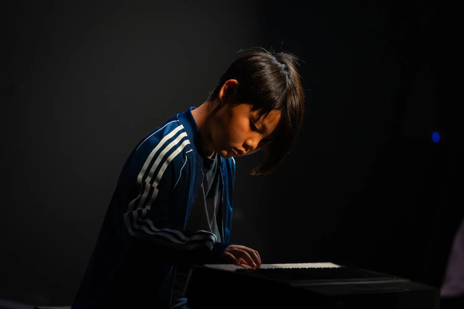 Young pianist focused at the keyboard during a private lesson